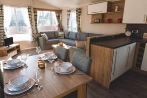 cocina y sala de estar con mesa y copas de vino en Premium Chalet at Newquay Away Resorts MV7 en Newquay