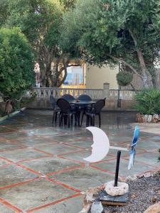 un patio con mesa, sillas y árboles en Villa Sa Rapita Familiar, en Sa Ràpita