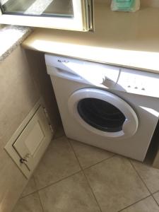 a white washing machine in a kitchen under a window at Confortevole e Luminoso Appartamento 100mq a Falerna con Vista sul Paese e sul Promontorio con Free WiFi Free Parking e Smart TV in Falerna