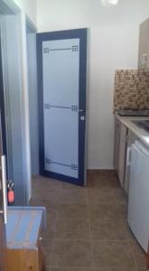 a room with a door in the middle of a kitchen at House Anna Houhlia in Vourvourou