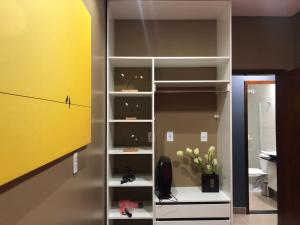 a closet with white shelves and a yellow wall at Penhasco Residences in Chapada dos Guimarães +287 photos