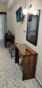 a bathroom with a wooden desk and a mirror at Minaides Hotel in Kakopetria