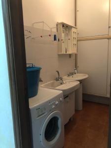 un bagno con lavatrice e lavandino di ClAnaGio House a SantʼAntonio Abate