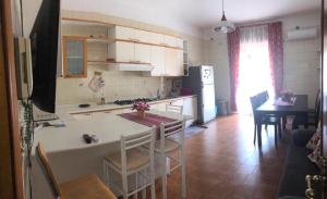 una cucina e una sala da pranzo con tavolo e una cucina con bancone di ClAnaGio House a SantʼAntonio Abate Altre 19 foto