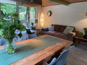 a living room with a wooden table and a couch at Uniek vakantiehuisje in rustige en groene omgeving in Nieuwe-Niedorp