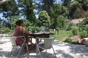 a woman sitting at a table in a garden at ribeira dos marinheiros amarelo in Sintra