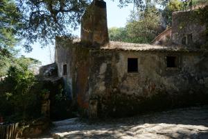 an old stone building with trees in the background at ribeira dos marinheiros amarelo in Sintra