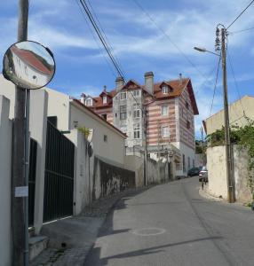 a mirror on the side of a street with buildings at ribeira dos marinheiros amarelo in Sintra