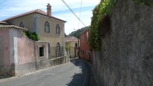 an alley in a town with buildings and a street at ribeira dos marinheiros amarelo in Sintra