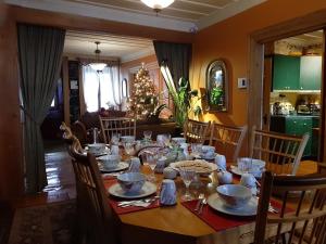 a dining room table with a christmas tree in the background at Gîte À l'Augustine in Quebec City