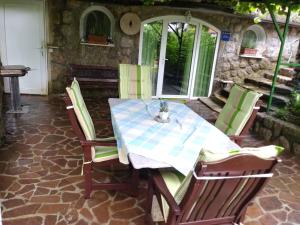 mesa con sillas verdes y mantel azul y blanco en Studio Apartman Lavanda, en Matulji