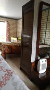 a bedroom with a bed and a dresser with a mirror at CHÁCARA QUEDINHA D'ÁGUA in Campo Alegre