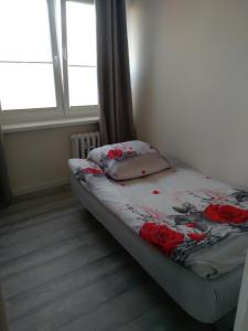 un letto in una stanza con dei fiori di Apartament Centrum a Radom