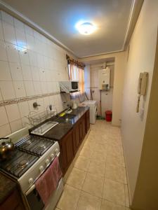 a small kitchen with a stove and a sink at Junin Centro Apartament in San Miguel de Tucumán