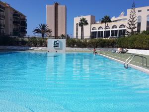 a large swimming pool with blue water in a building at Cristimar - stunning Vacation Rental Home for families & friends in Los Cristianos