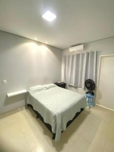 1 dormitorio con 1 cama en una habitación blanca en Suite Confortavel em Chapada dos Guimaraes, en Chapada dos Guimarães