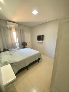 Un dormitorio con una cama y un televisor en la pared. en Suite Confortavel em Chapada dos Guimaraes, en Chapada dos Guimarães
