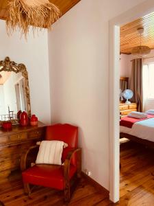 Un dormitorio con una silla roja y una cama en Vila Aurora, en Parada de Gatim