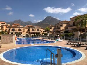 una piscina in un resort con montagne sullo sfondo di Villa Del Duque with private pool ad Adeje