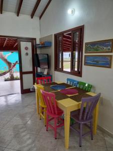 uma sala de jantar com uma mesa e cadeiras coloridas em Casa Lagoa e Praia Rosa na Praia do Rosa