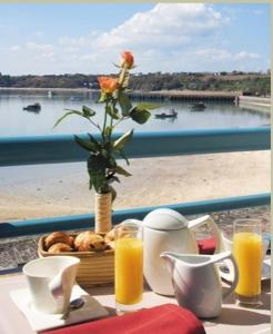 une table avec un vase avec une fleur et un panier de pain dans l'établissement La Mere Champlain, à Cancale