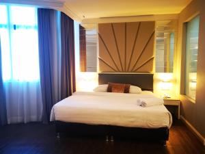 
a hotel room with a large bed and a large window at Regalodge Hotel Ipoh in Ipoh
