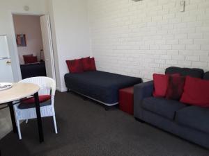 
a living room with a couch and a table at Narooma Golfers Lodge in Narooma
