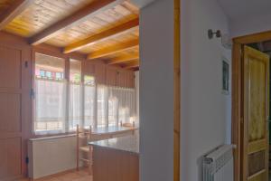 a kitchen with a table and some windows at Caxila Apartamentos Rurales - Luarca - Asturias in Setienes