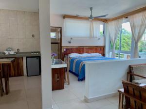 a kitchen and a bedroom with a bed and a window at Lidxi Rosae in Puerto Escondido