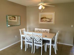una sala da pranzo con tavolo e sedie bianchi di Island House Beach Resort 26 a Point O'Rocks