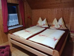 een slaapkamer met 2 bedden in een houten kamer bij Ferienhütte Antonia in Kliening