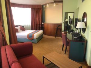 Pokój hotelowy z łóżkiem i biurkiem w obiekcie Al Diar Dana Hotel w Abu Zabi