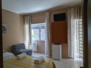 um quarto com uma cama, uma cadeira e uma janela em B&B Gina Trastevere em Roma