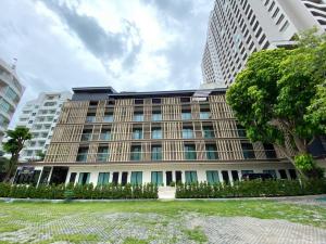 a large building in front of a tall building at The Shade Residence in Pattaya