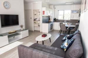 a living room with a couch and a table and a kitchen at Lotus Stay Manly - Apartment 29G in Sydney
