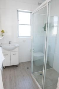 y baño con ducha acristalada y lavamanos. en Lotus Stay Manly - Apartment 29G en Sídney