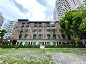 a building in front of a tall building at The Shade Residence in Pattaya
