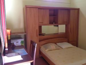 a small bedroom with a bed and a desk with a desk at Chambres D'hôtes AISSA in Saint-Denis