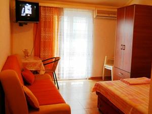 salon z kanapą i telewizorem w obiekcie Apartmani M Igalo Crna Gora w mieście Igalo