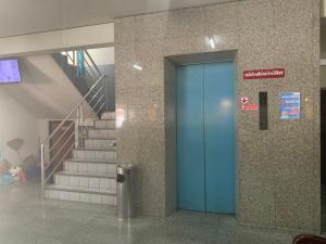 a blue door in a building with stairs at Prontip Place in Godown