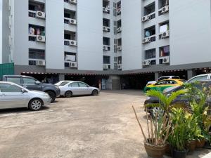 a parking lot with cars parked in front of a building at Prontip Place in Godown