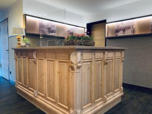 a lobby with a wooden counter with flowers on it at Stadthotel Kachelofen in Krumbach