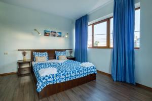 a bedroom with a bed and blue drapes at Casa Lotca in Costinesti