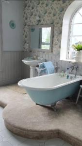 y baño con bañera blanca y lavamanos. en Ballyginniff Farm House en Crumlin