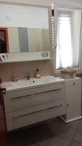 a bathroom with a white sink and a mirror at Apartment Možina in Koper