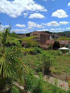 uma vista para um jardim com um edifício ao fundo em Villa Raphaël em Cransac