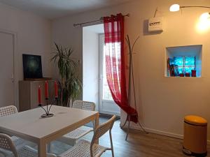 comedor con mesa, sillas y ventana en Villa Raphaël, en Cransac