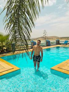 un hombre parado en el agua en una piscina en Rive Du Lac, en Lalla Takerkoust