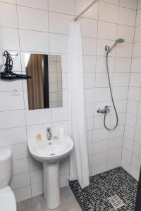 ein weißes Bad mit einem Waschbecken und einer Dusche in der Unterkunft RedFox Hotel in Barnaul