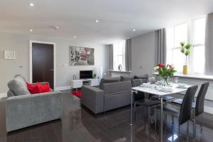 a living room with a couch and a table at Deluxe Central City of London Apartments in London